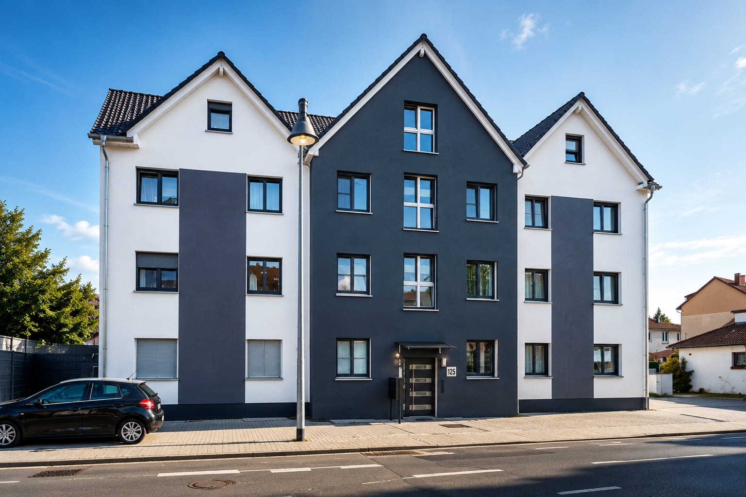 Straßenansicht desselben Mehrfamilienhauses bei Tageslicht